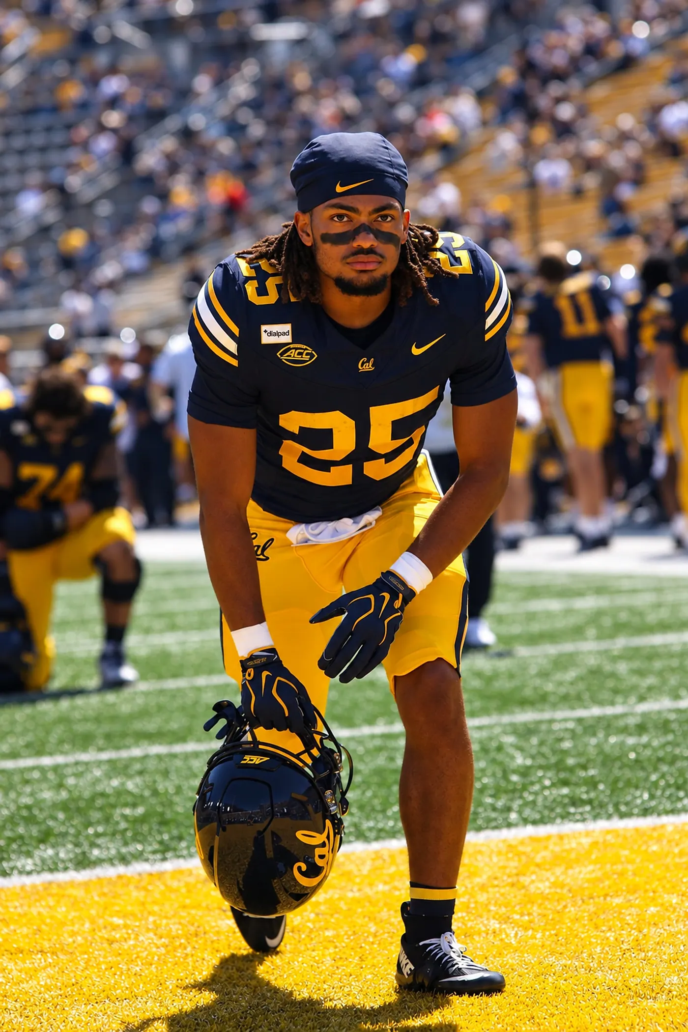 Cal running back number 25 kneeling on the field before kickoff, helmet in hand